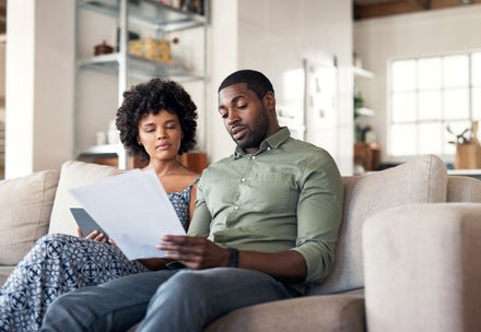 A young couple going through insurance papers at home