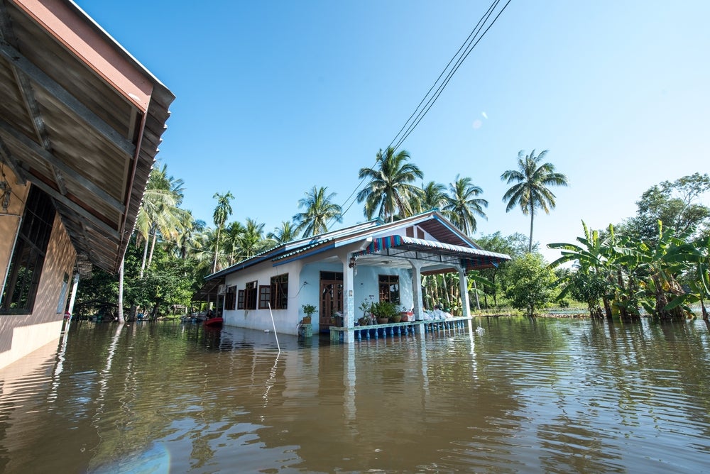 A small home half submerged in flood waters