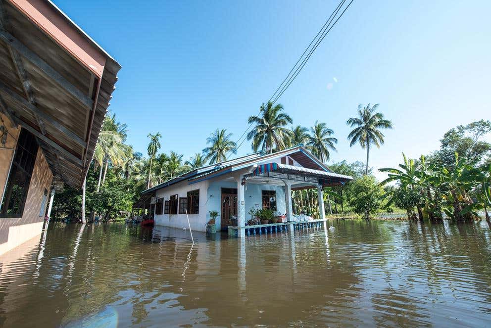 A small home half submerged in flood waters