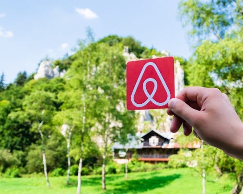 Airbnb Logo in front of a properly insured home.