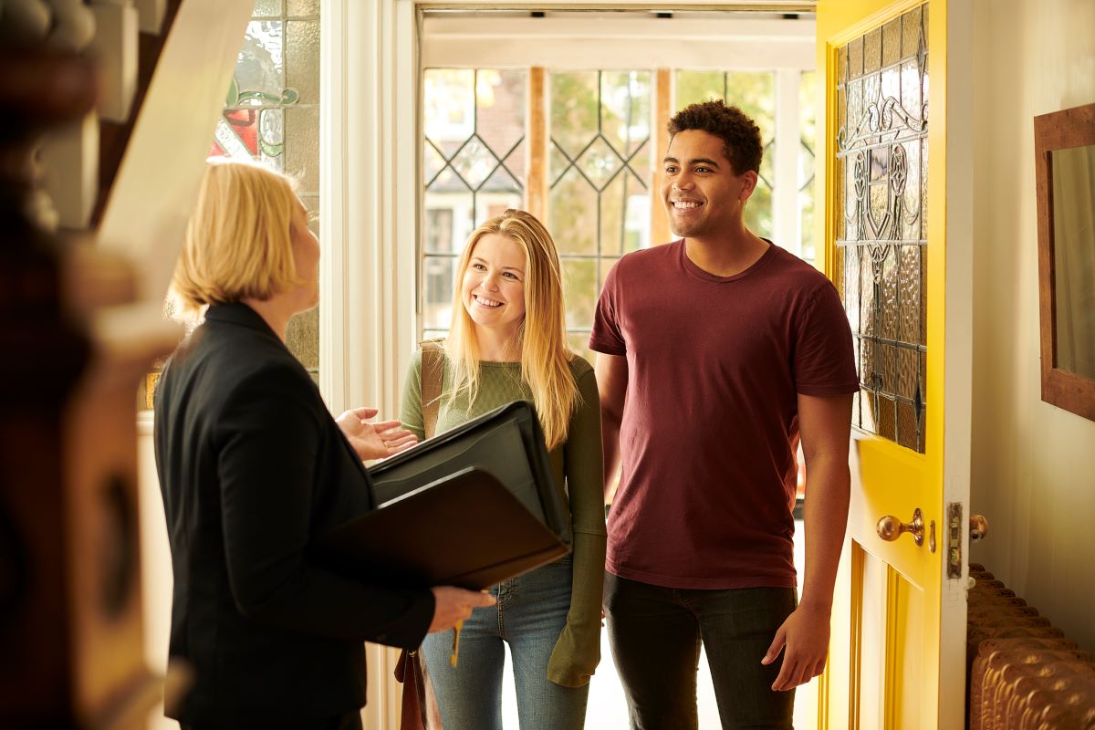 A young couple meet their real estate agent at an open house