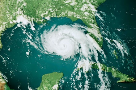 An image of a hurricane on a topographic map of the Gulf of Mexico.