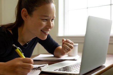 Closeup of a young woman looking closely at her laptop