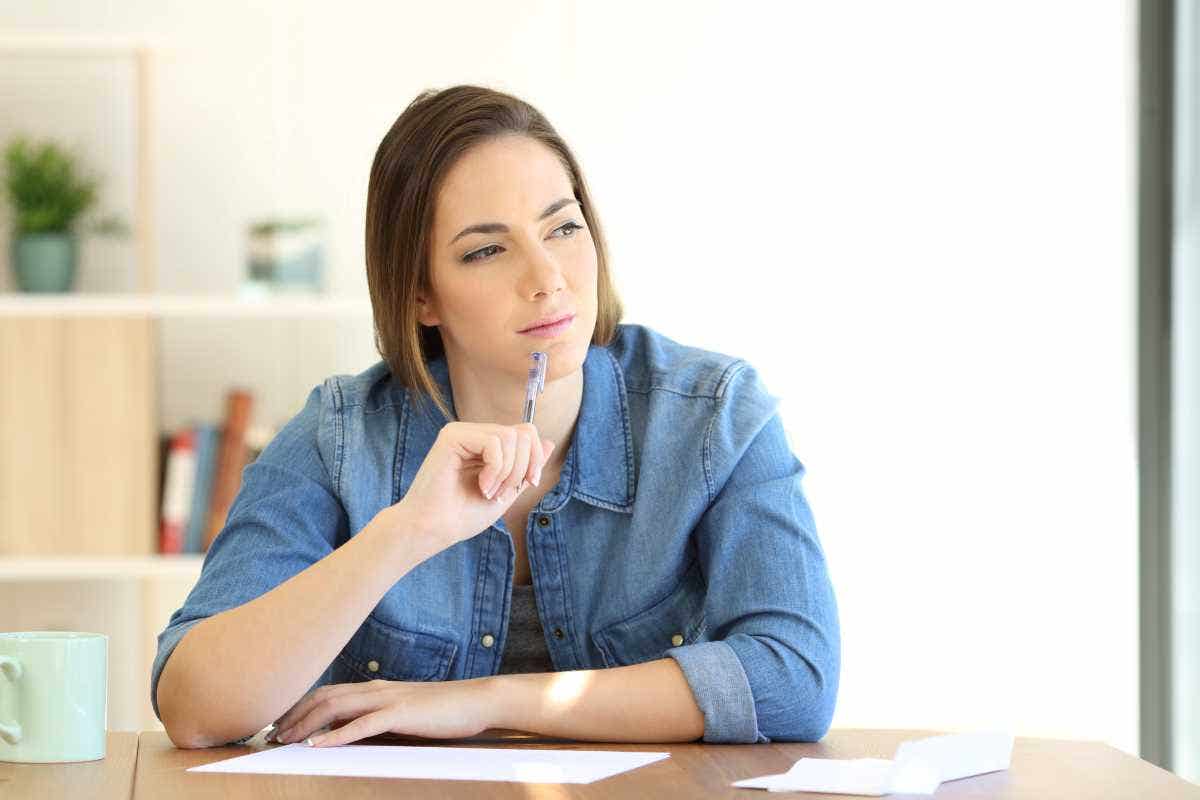 A serious woman sits at her table as she considers her home insurance deductible