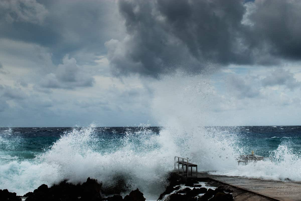 Waves crashing on a rocky shorline as storm clouds gather