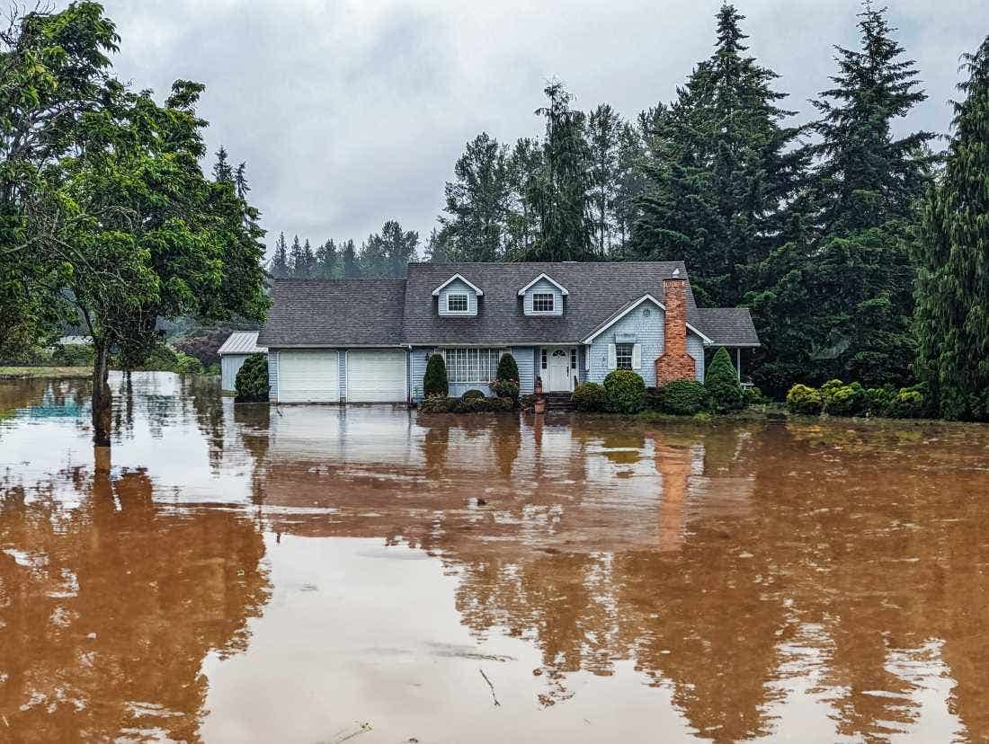 A home surrounded by muddy floodwaters