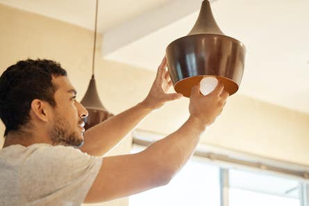 A man screwing in a ligh bulb