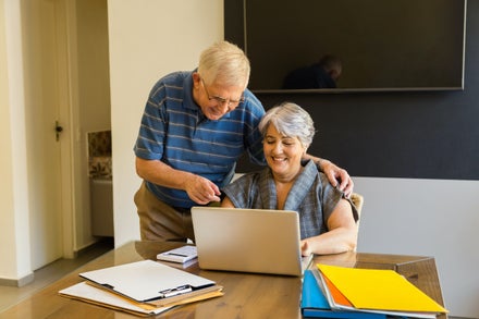 Senior couple at their kitchen table working on their taxes