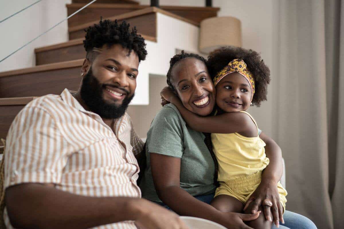 A happy father, mother, and daughter in their home