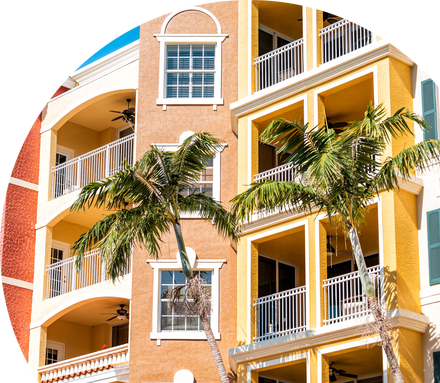 A row of brightly colored, two-story condos on a street lined with palm trees