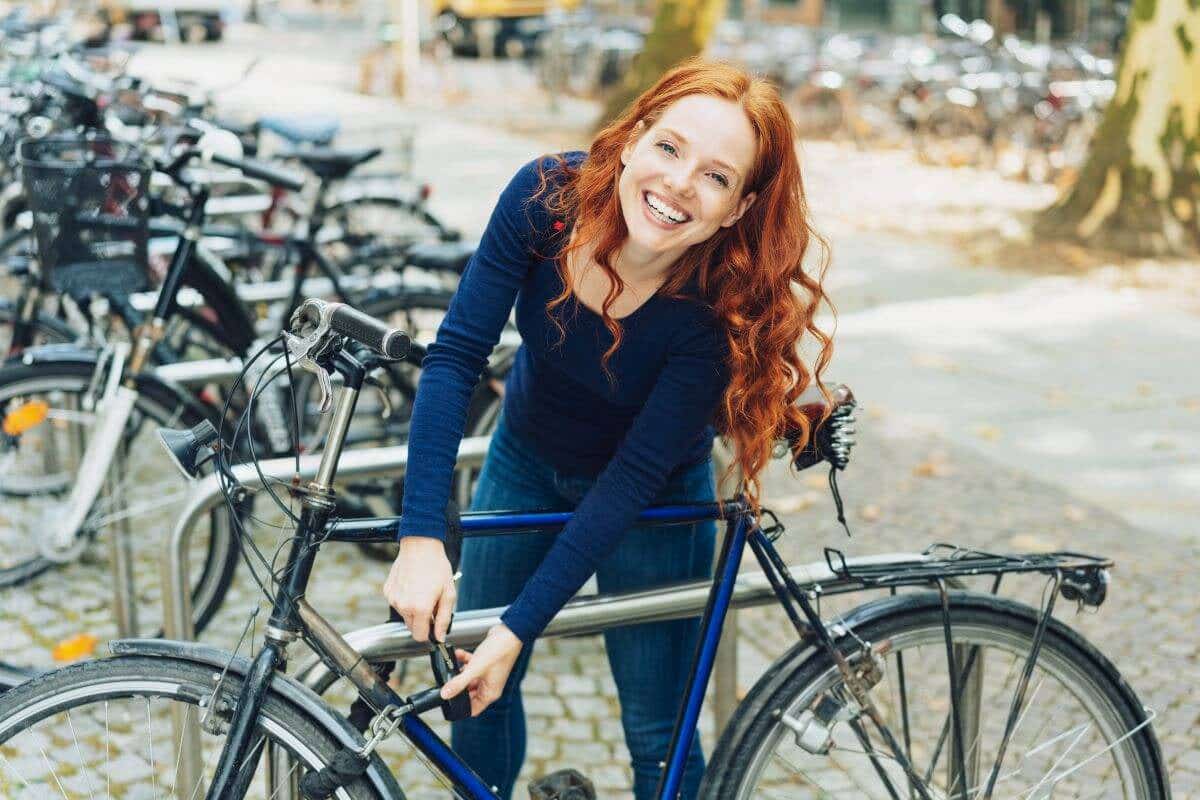 A woman smiles while locking up her bike
