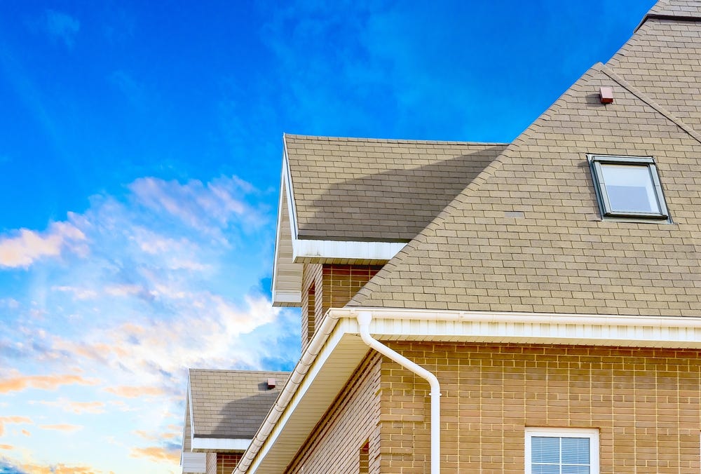 A brick home with a shingled roof