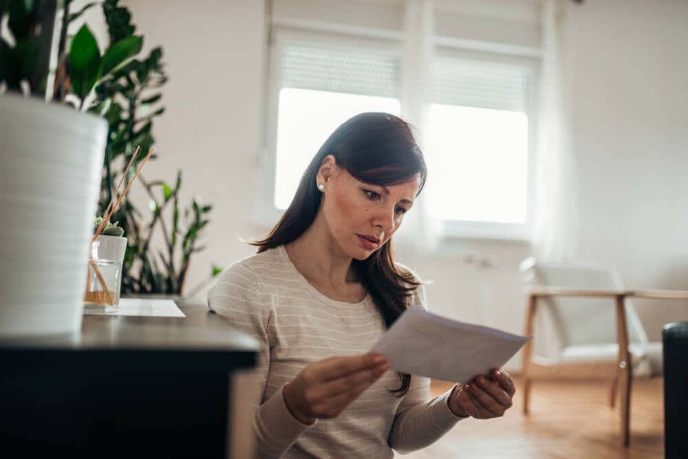 A woman looks intently at a piece of paper