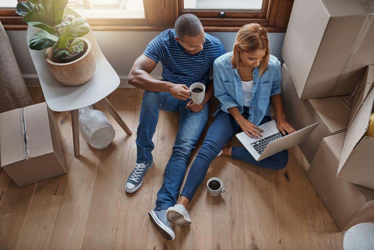 Couple sitting on the floor of their new home, reviewing home insurance options