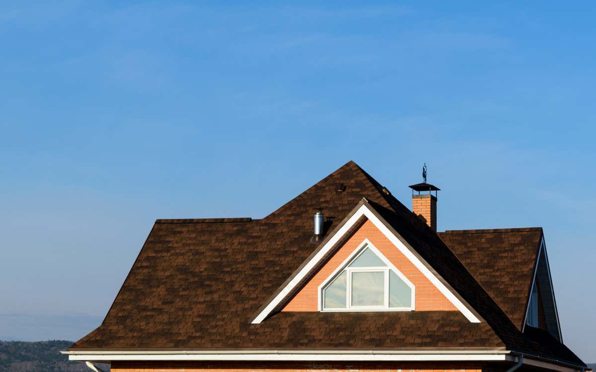 a gable roof on a modern house with a blue sky in the background