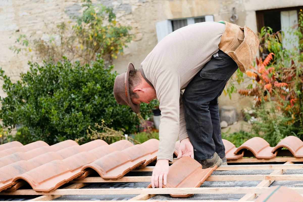 A roofer repairing clay tiles