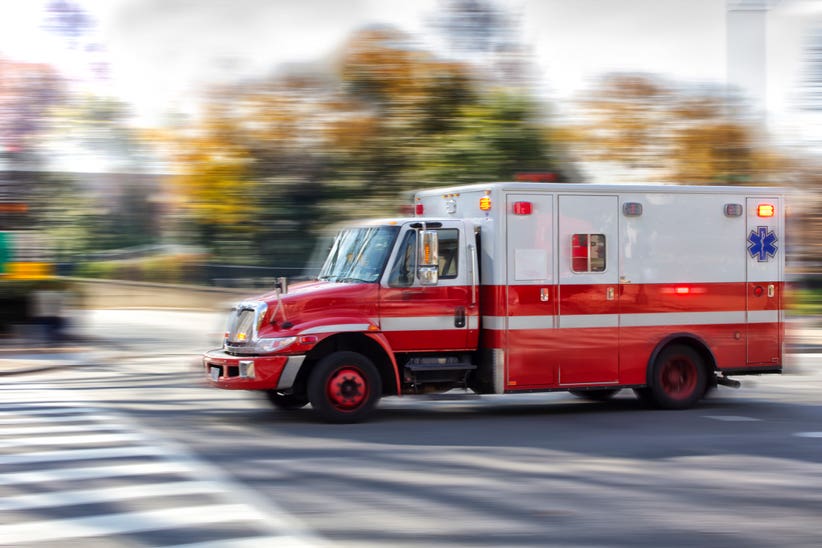 An ambulance moving through traffic