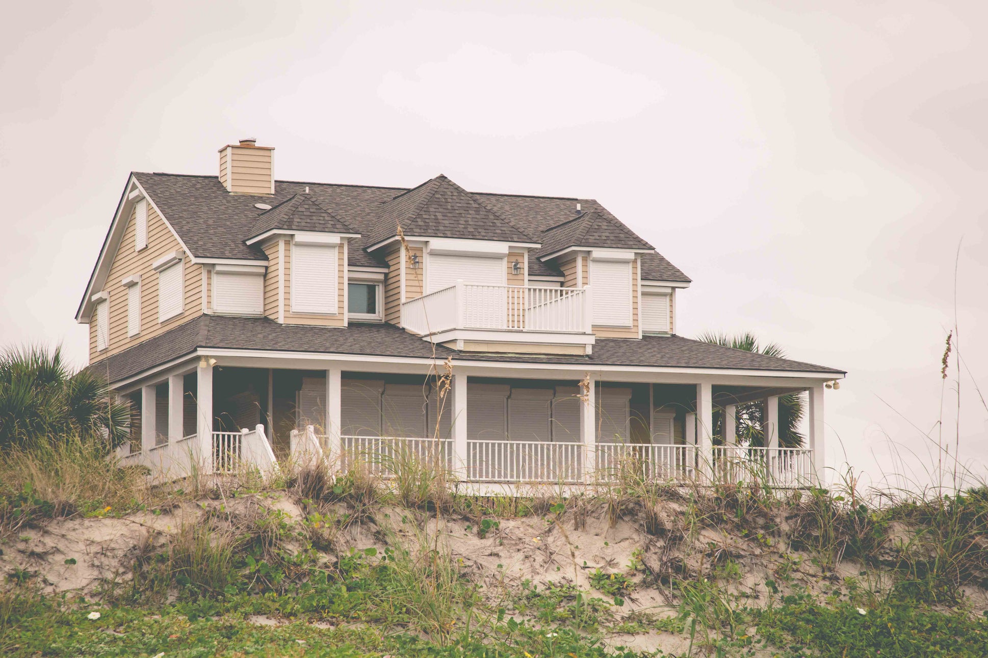 A two-story coastal home with hurricane shutters