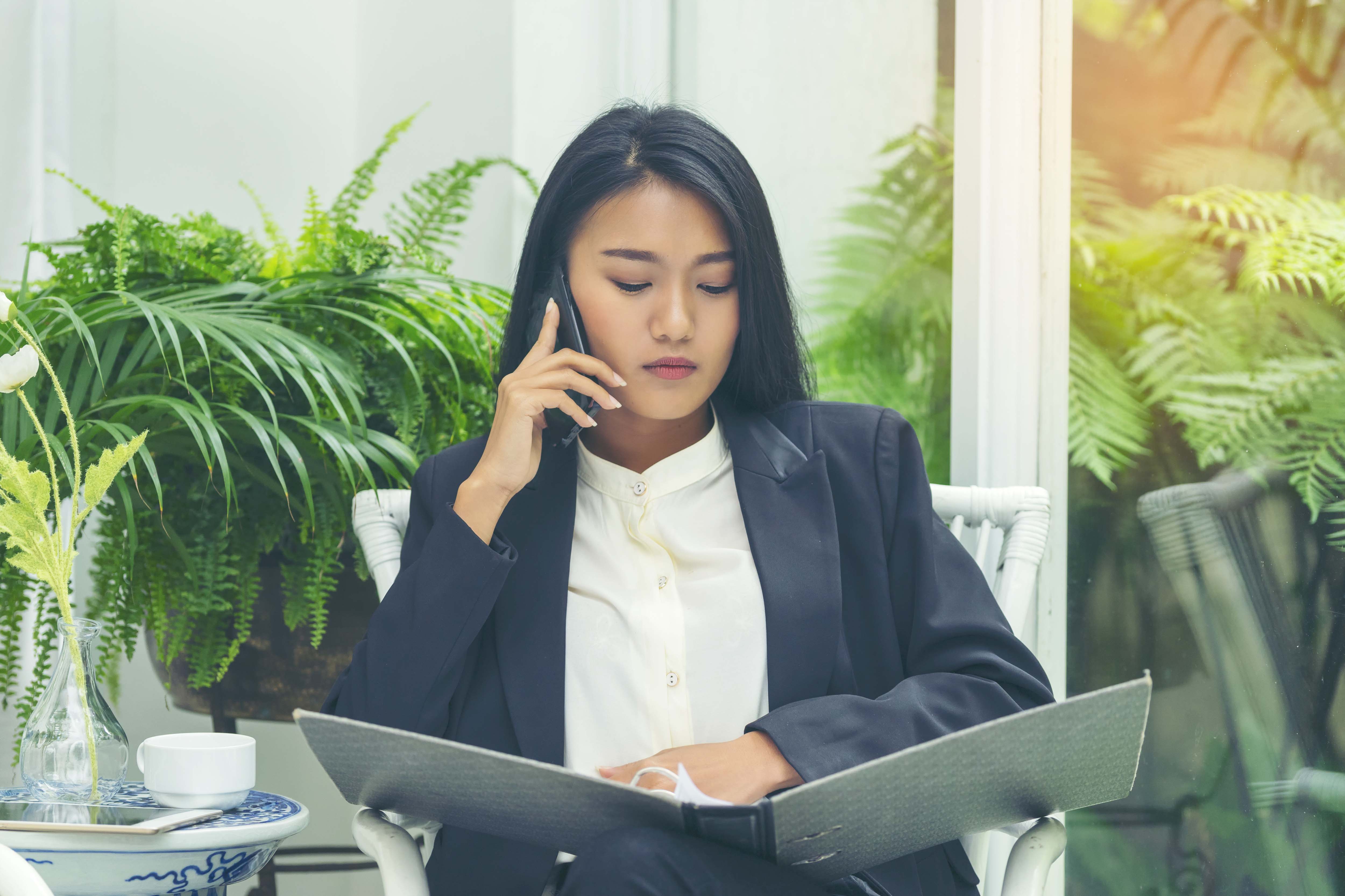 An insurance broker on the phone, reviewing a file