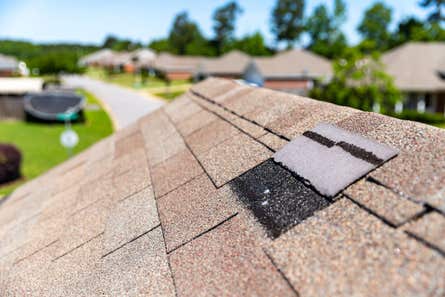 Missing shingles on roof due to storm damage.