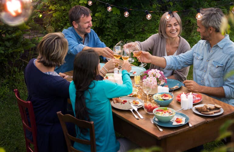 Five people enjoying a meal in the backyard