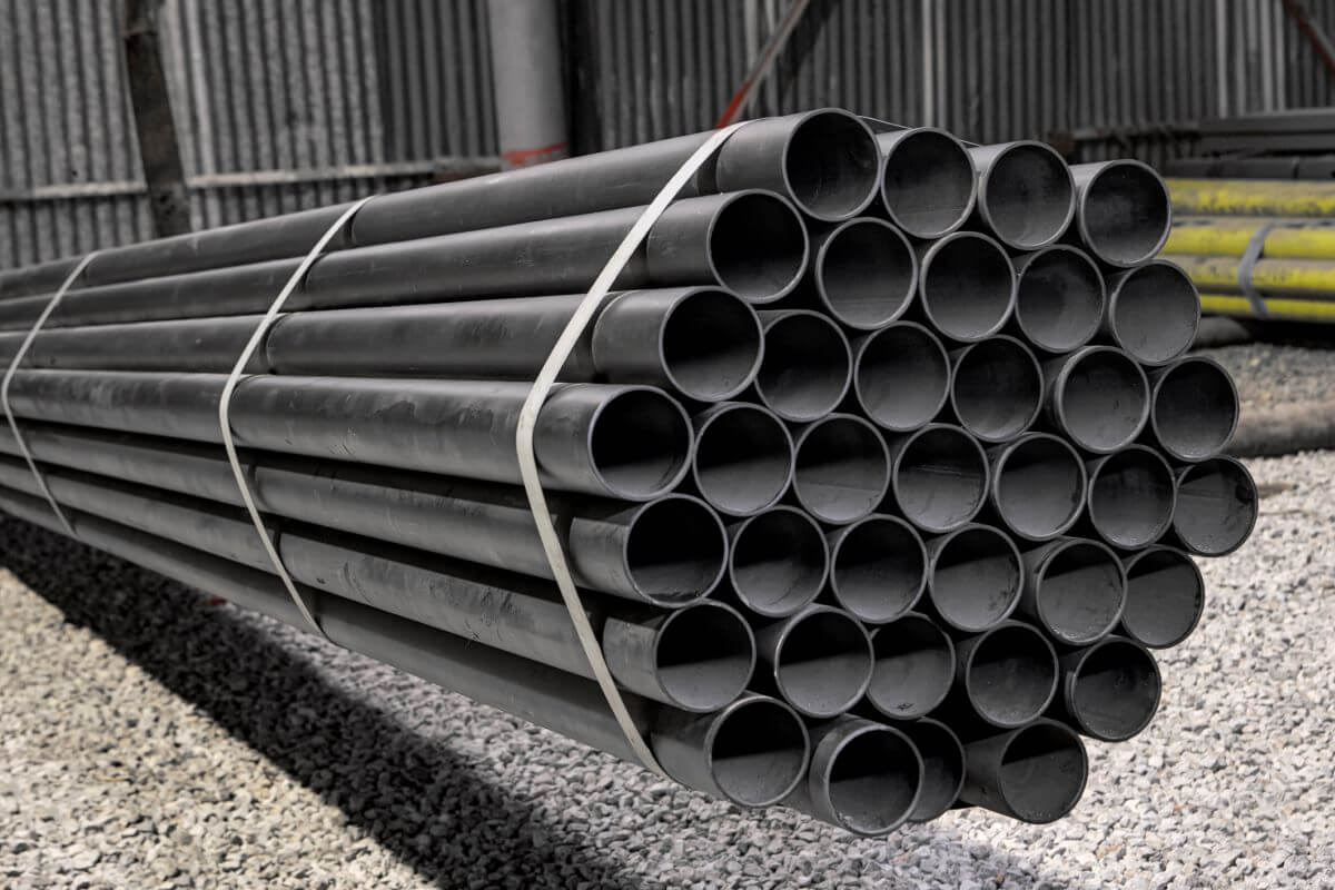 A bundle of galvanized steel pipes in a warehouse yard