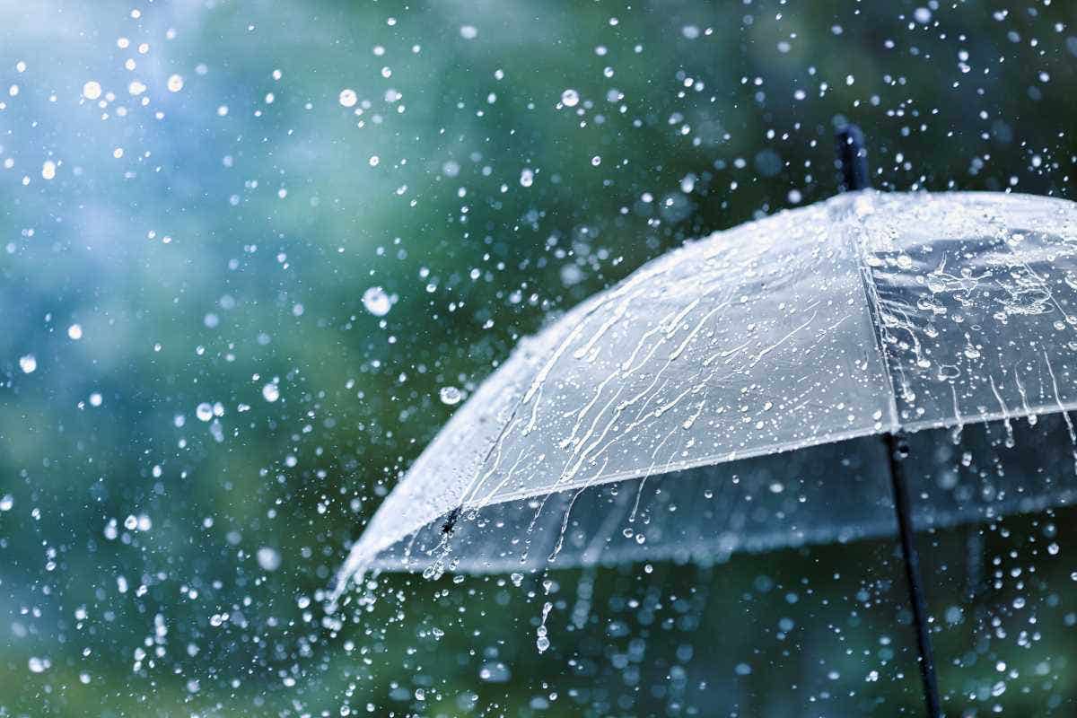 Transparent umbrella under heavy rain against water drops splash background