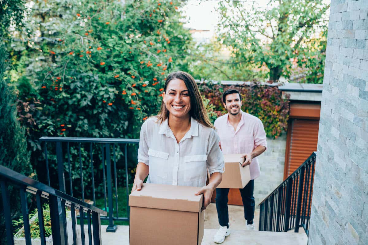 A couple moving boxes into their new home