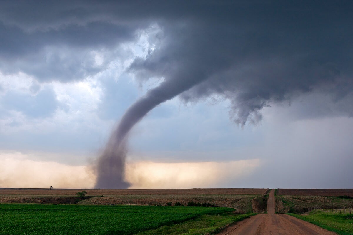 A tornado funnel spins beneath a supercell thunderstorm during a severe weather event