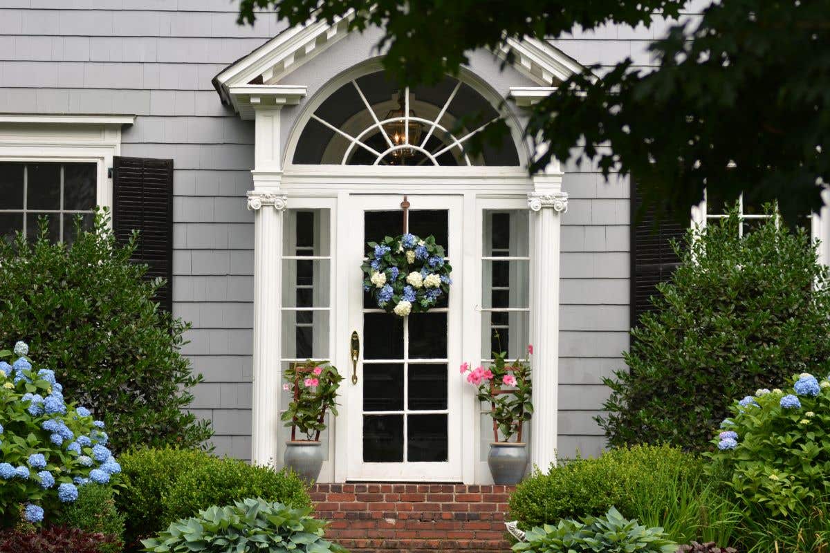 Glass door with white trim on a grey home