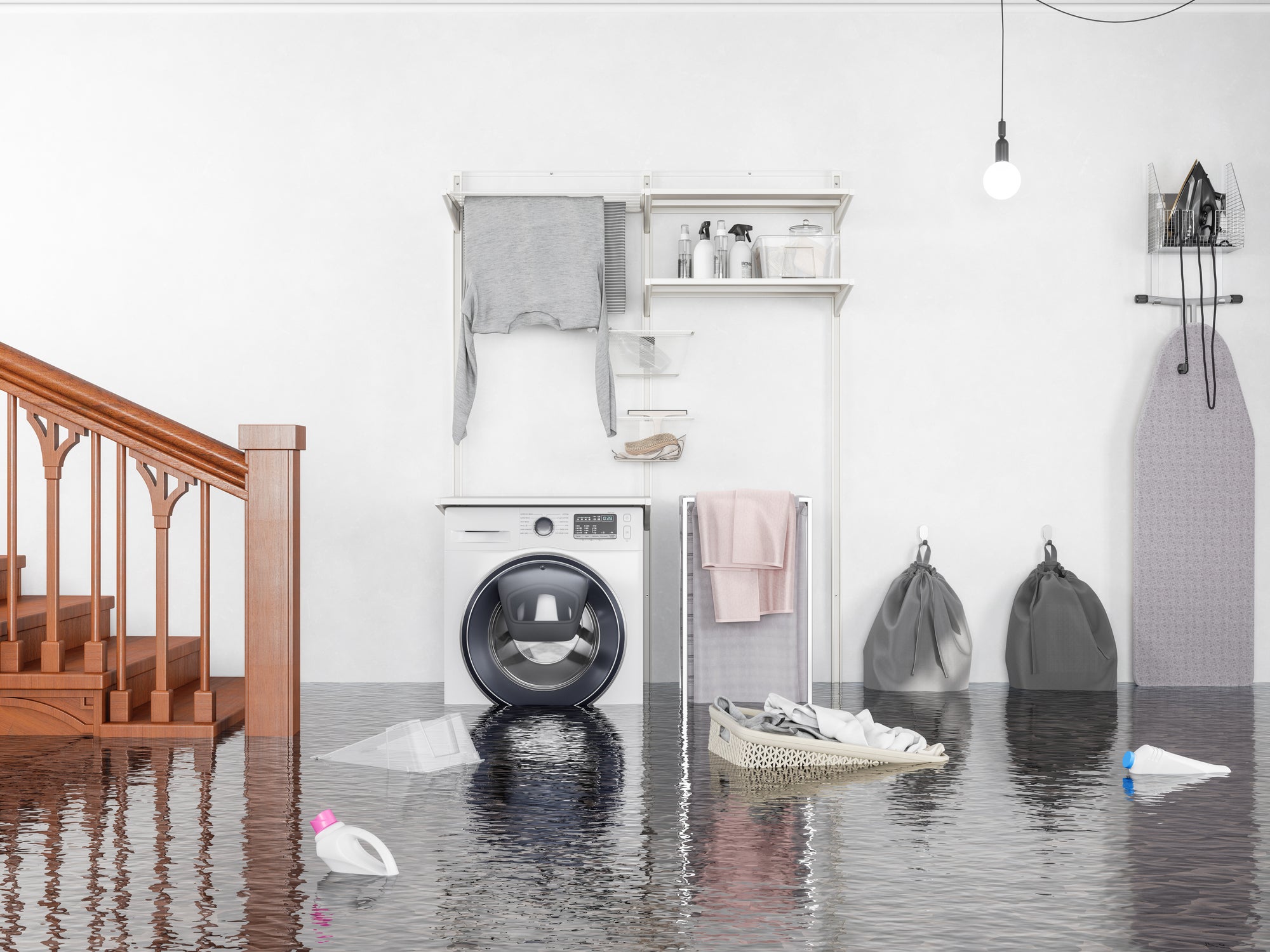 flooded laundry room with staircase to the left of a washer, dryer, and ironing board
