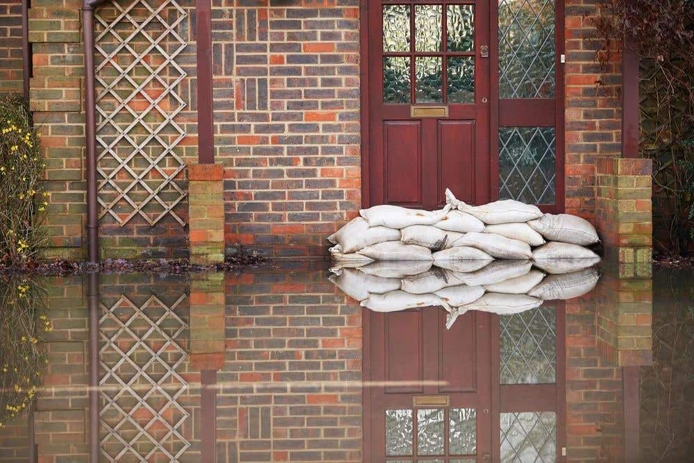 A home's front door surrounded by water and sandbags