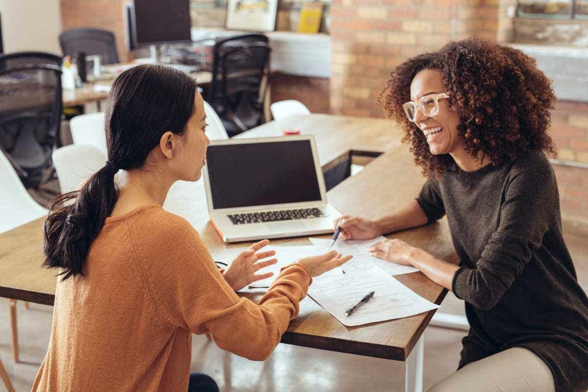 An insurance agent sits with a young homeowner to work on their coverage