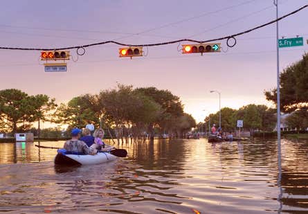 people in a kayak on a flooded street