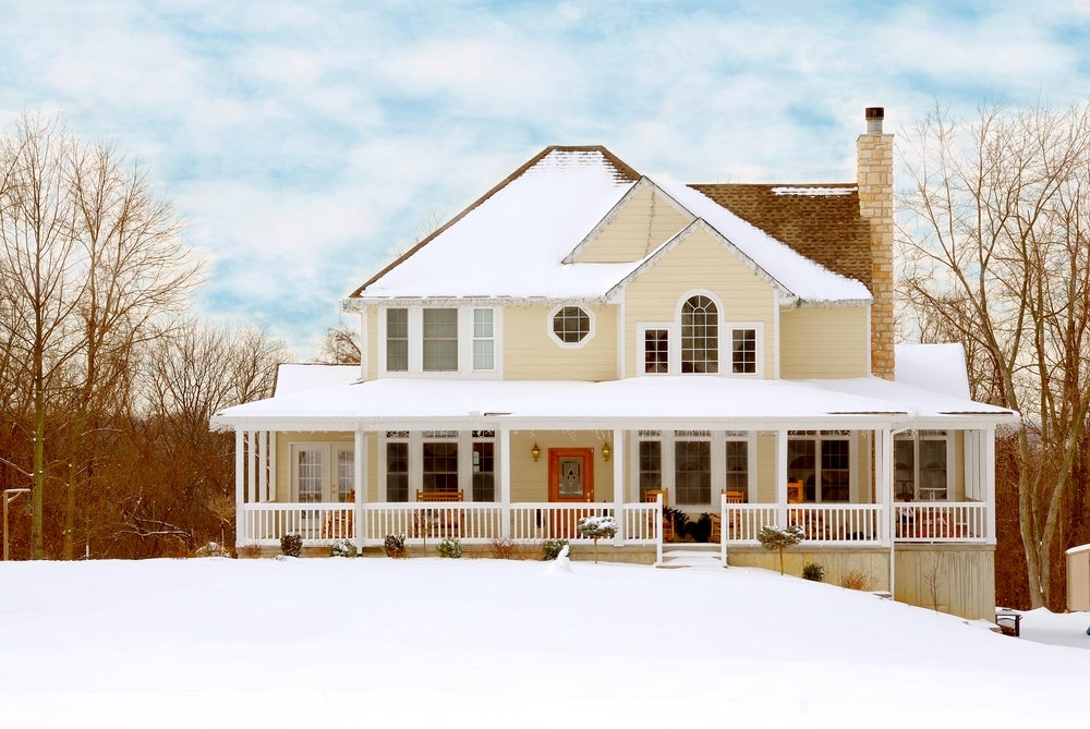 Two-story home with snow on the roof and in the yard
